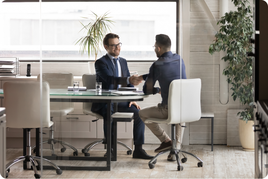 Two men shaking hands in a meeting