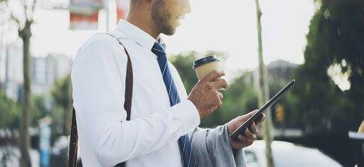 attorney walking to work with his phone and coffee in hand