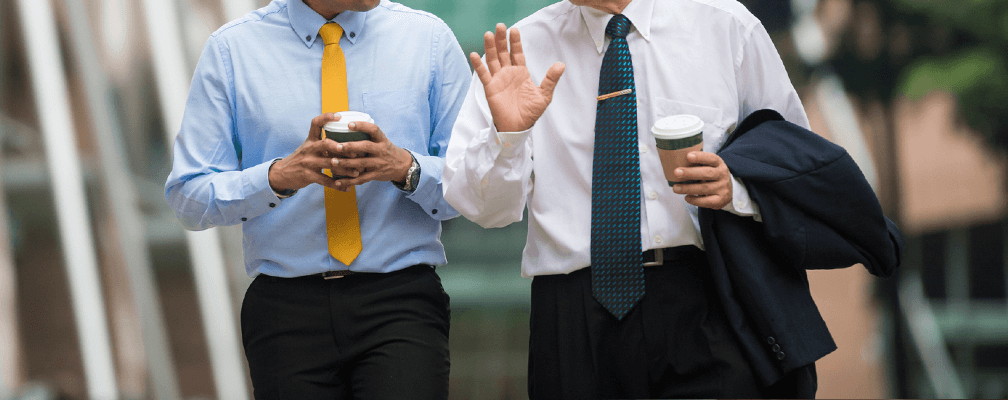 Two businessmen walking with coffee