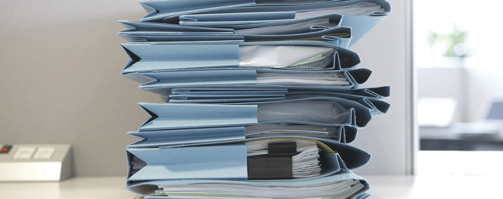 Stack of blue file folders filled with papers