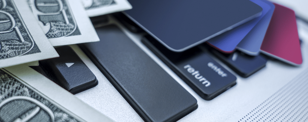 credit cards and money on laptop keyboard