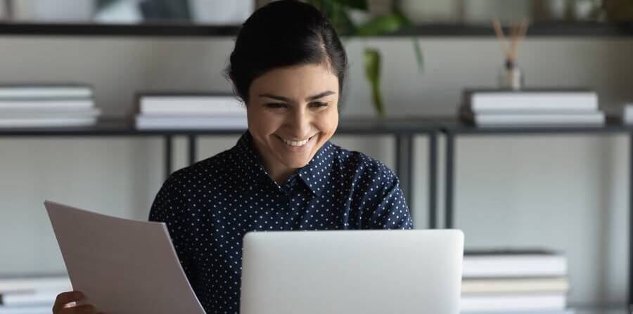 woman smiling at her laptop happy that she's reducing non-billable hours
