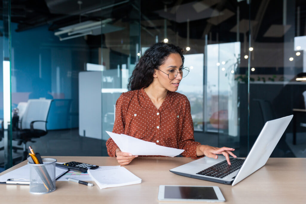 header image lawyer in office working on laptop holding papers