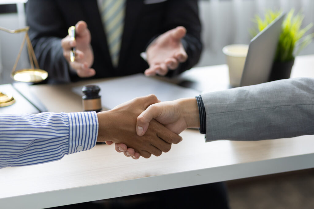 image header, two parties shaking hands after mediation with a lawyer sitting behind desk