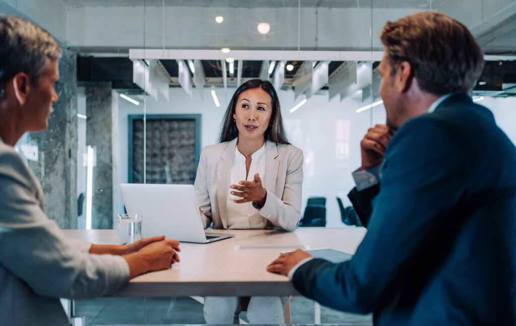 header image lawyer using laptop talking to fellow lawyers in conference room