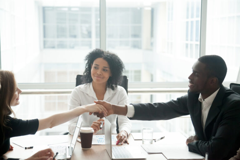 header image attorney mediating two clients shaking hands over table in agreement