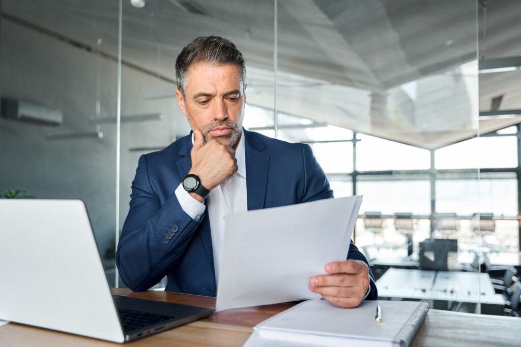 header image of male lawyer sitting behind desk looking at paper in hand