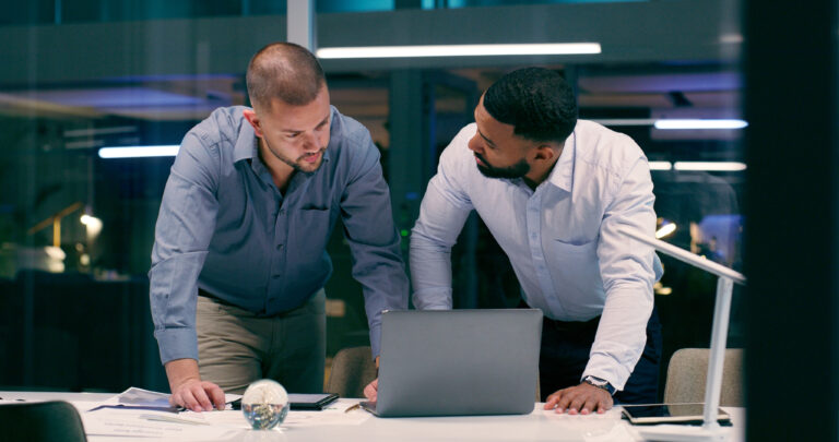 header image of two lawyers standing over a table and laptop