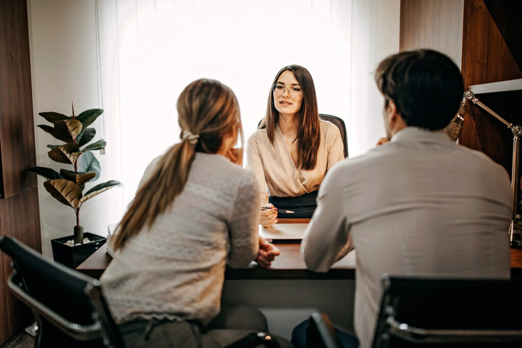 header image of lawyer behind desk facing a couple looking to get married and sign a prenuptial agreement