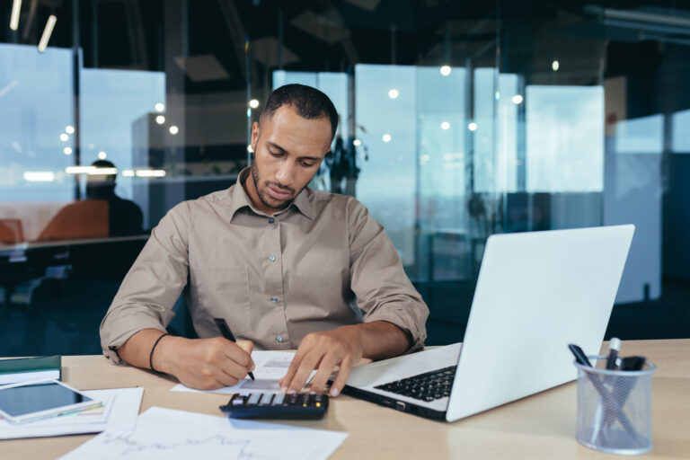 header image of attorney sitting at desk working on billing using a calculator