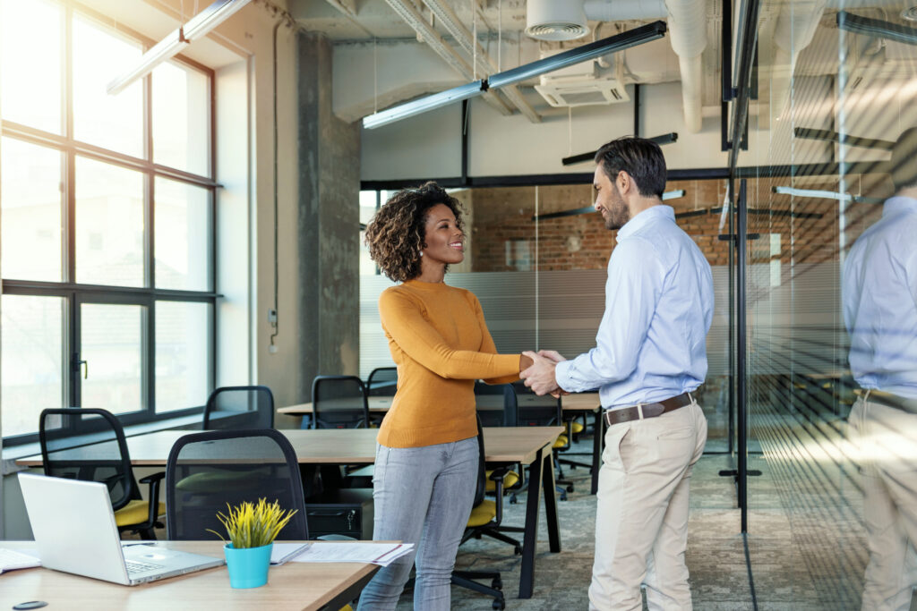 header image of lawyer welcoming new lawyer to the law firm in a conference room.