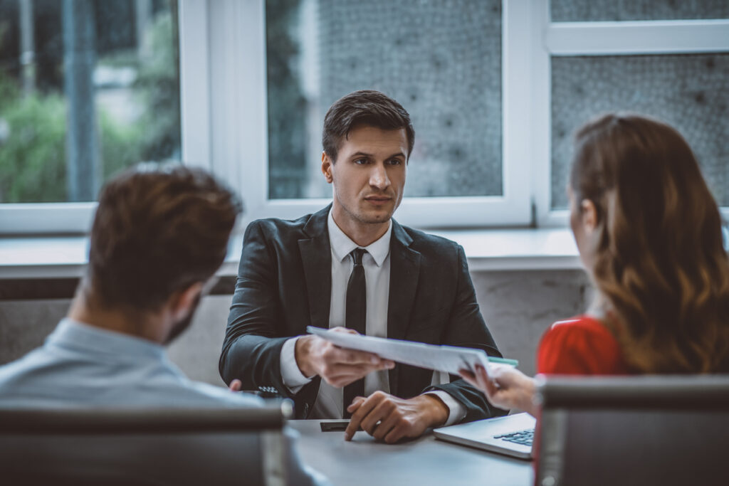 header image of lawyer behind desk talking with clients in office