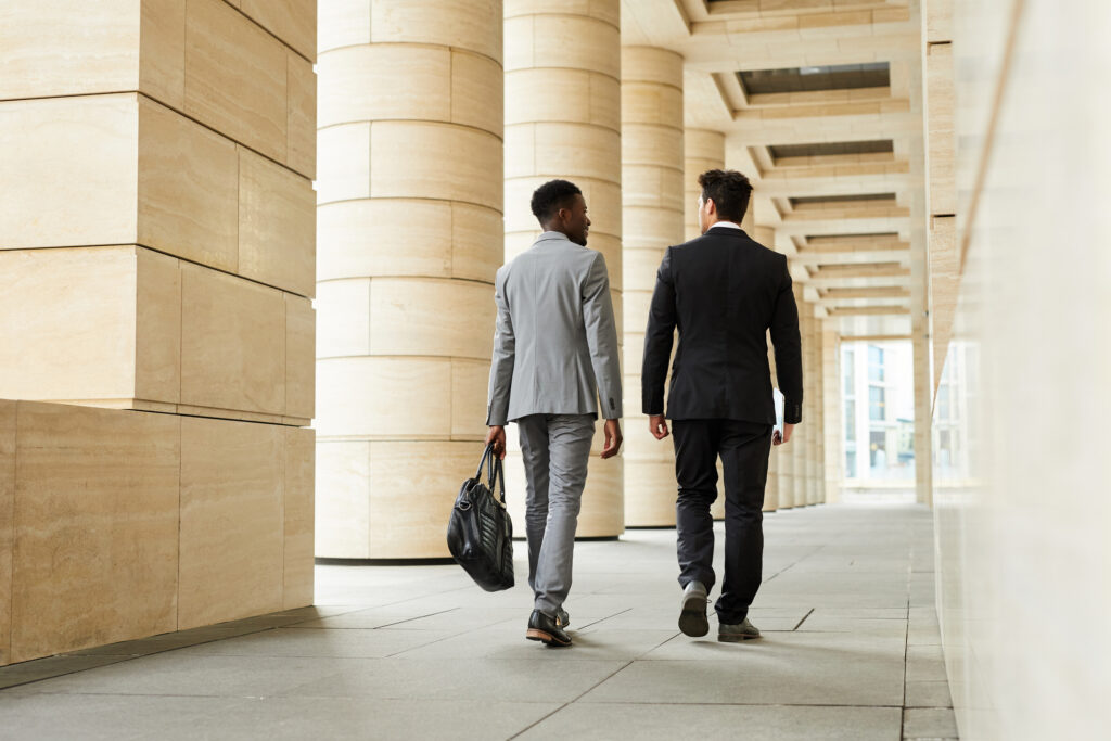Two legal professionals walking down hallway